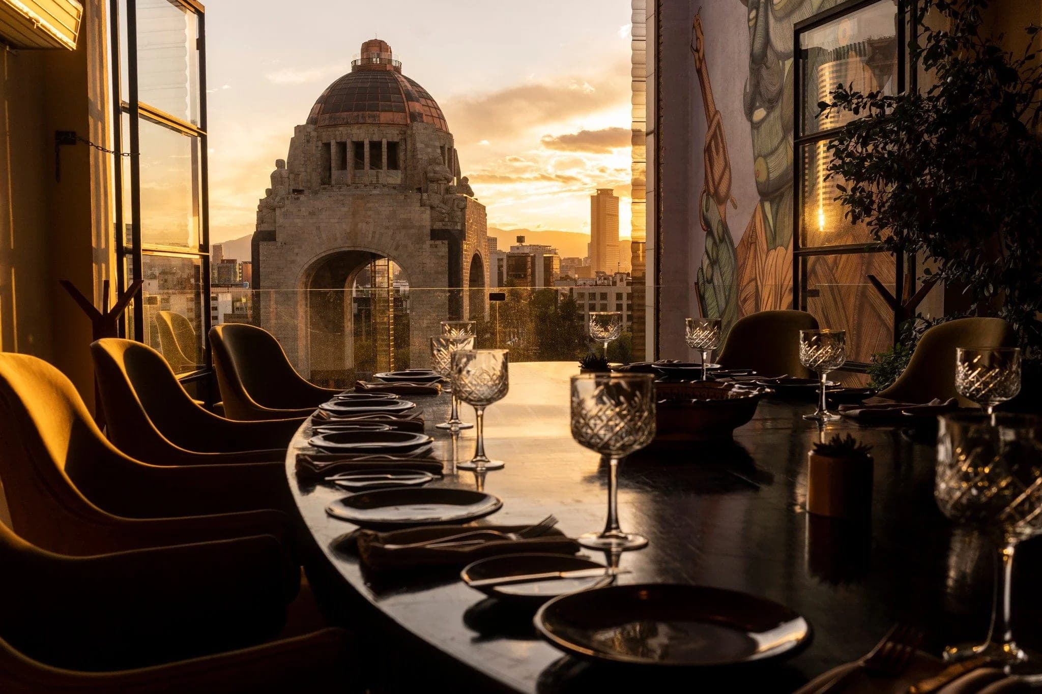A dining counter facing the Monumento a la Revolución as the sun sets over Mexico City