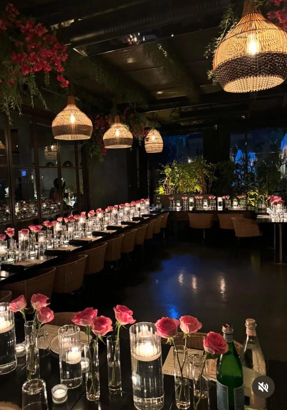 Two long tables laid with roses and votive candles for a private dinner in the empty dining room