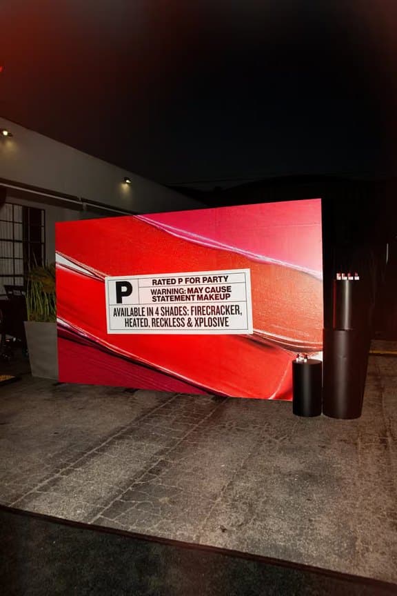 A red Smashbox wall printed with a “Rated P for Party” warning placard.