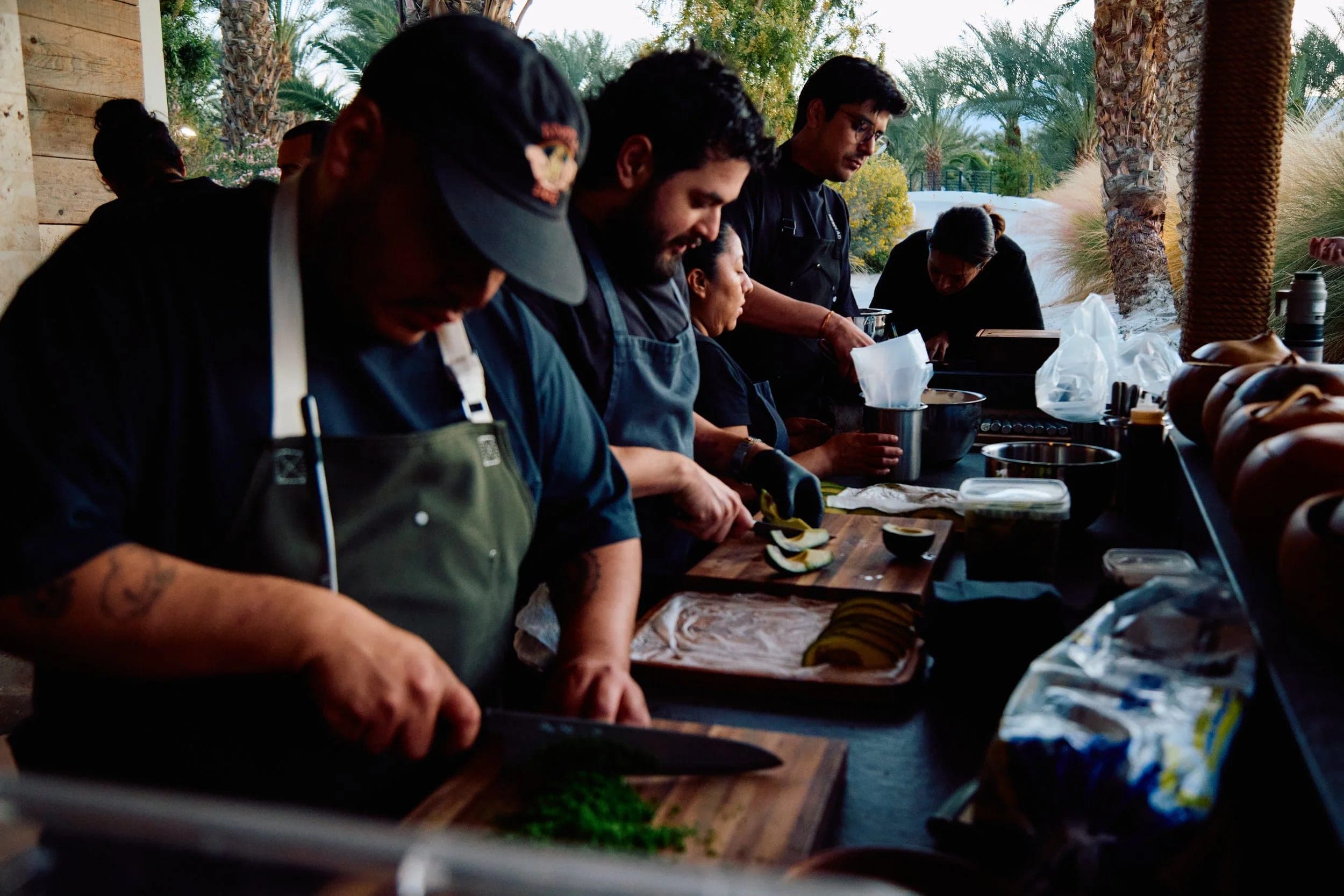 Chefs working shoulder to shoulder along the prep line, plating the next course