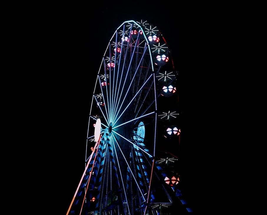 The Neon Carnival Ferris wheel picked out in coloured lights against a black desert sky
