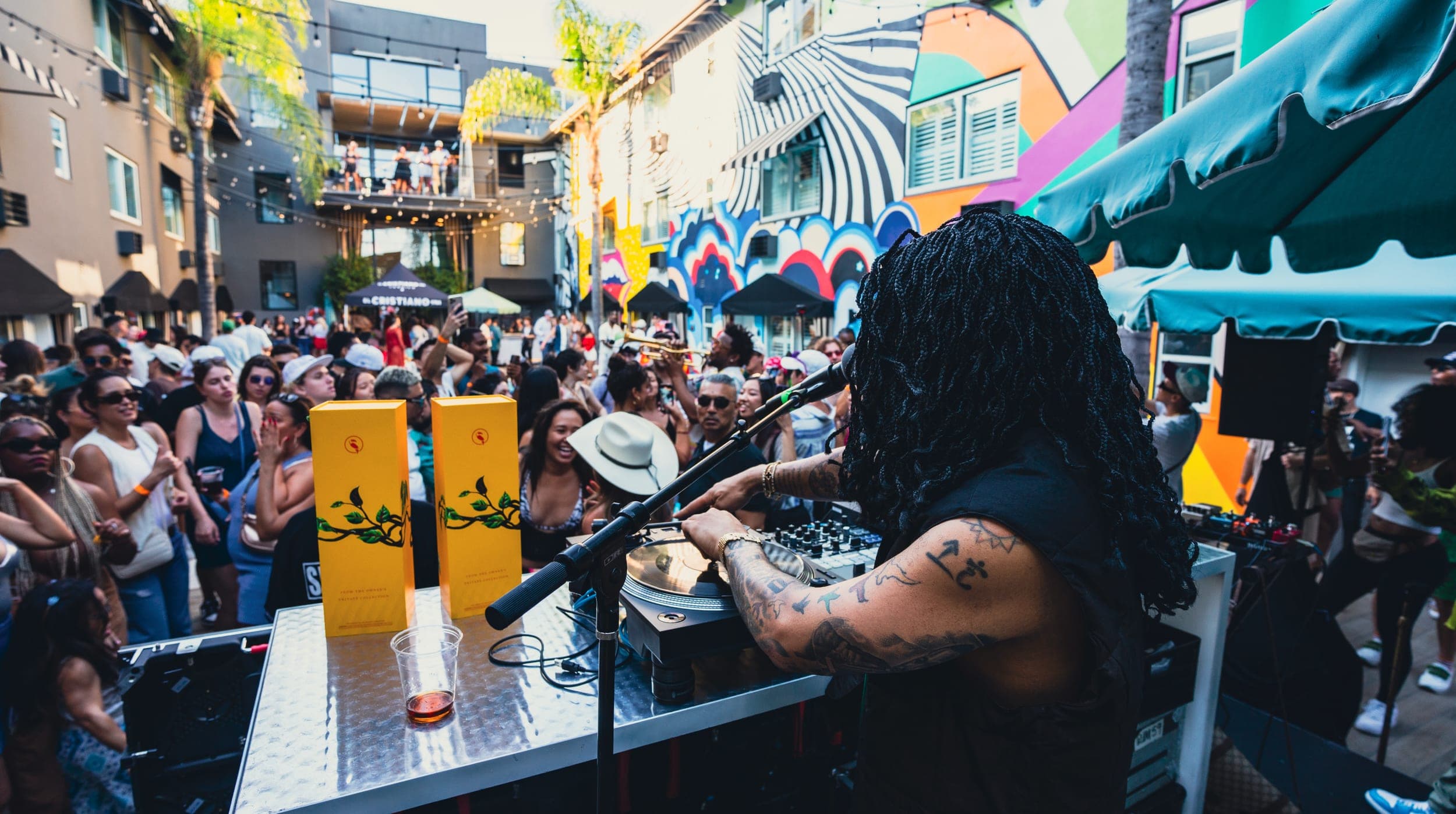 The DJ working the turntables with the packed Hotel Ziggy courtyard stretching out behind