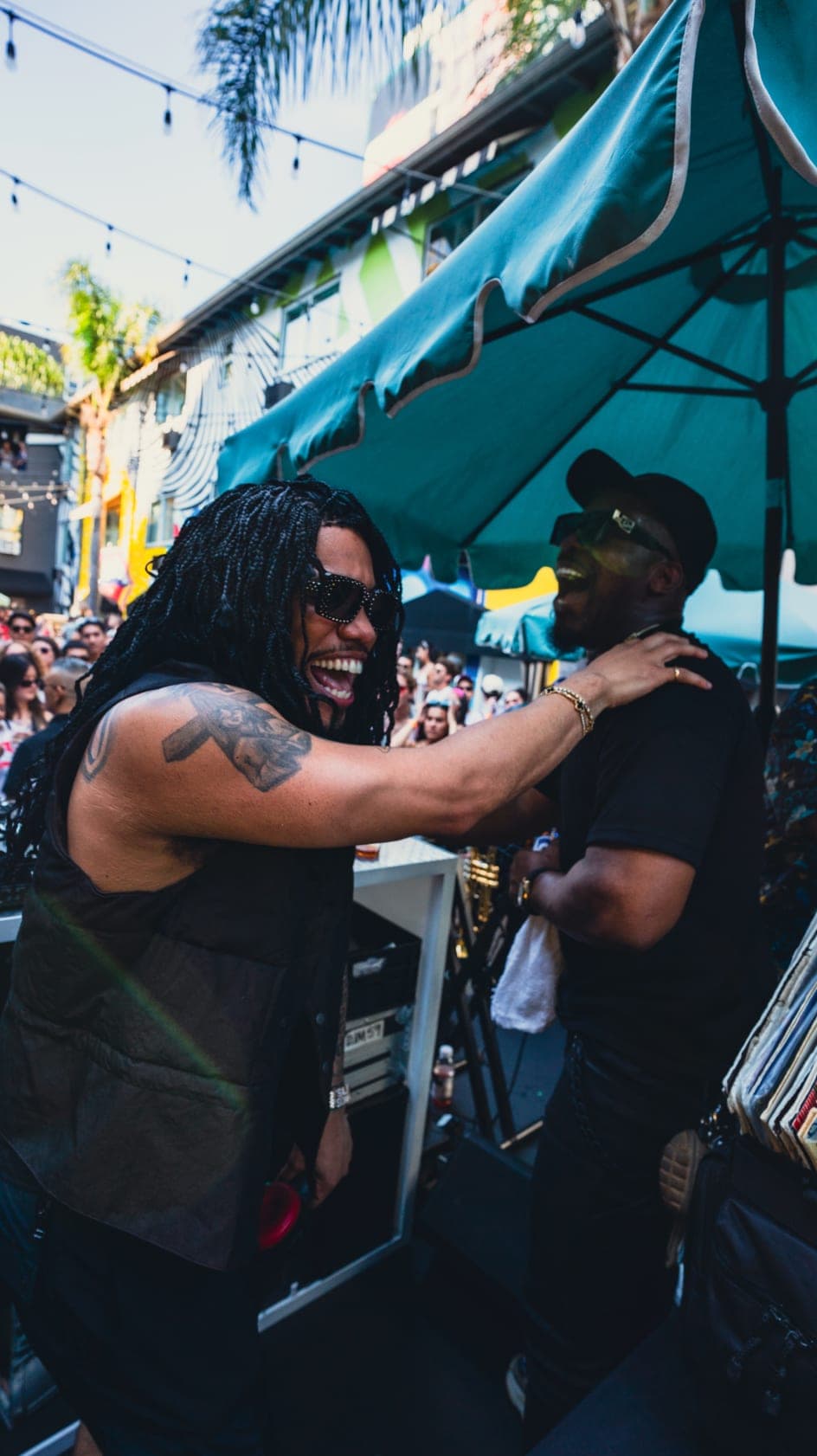 The DJ laughing with a friend beside the booth halfway through the set